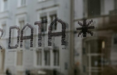 a close up of a window with a building in the background